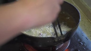 A chef is frying pork belly in a frying pan