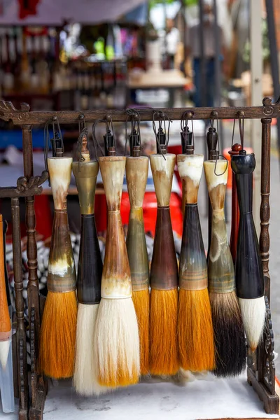Close-up of various traditional Chinese brushes sold in the market