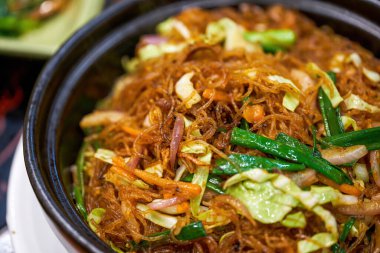 Lezzetli bir Çin yemeği, vejetaryen kızartılmış vermicelli ve killi çömlek.