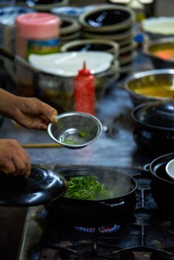 Bir şef jiu jiu pot yapıyor, ünlü bir Kanton yemeği.