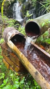 Slow motion of running water of a stream drainage system made of bamboo