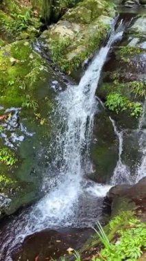 Slow motion video of small waterfall flowing in mountain stream in Guilin, Guangxi, China