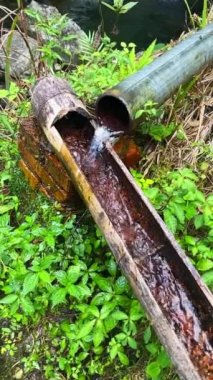 Slow motion of running water of a stream drainage system made of bamboo