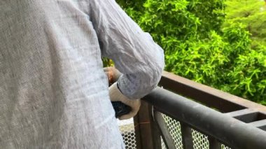 A worker is using a cutting machine to cut an iron guardrail to escalate in slow motion