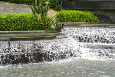 Landscape of man-made flowing water fountain in the park
