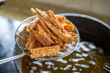A chef in the kitchen is making fried yuba