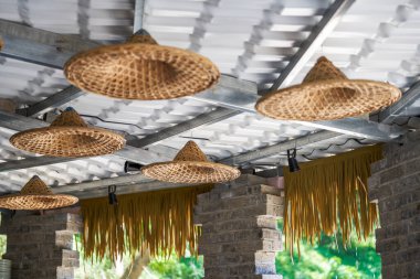Rural house ceiling covered with straw hat decoration