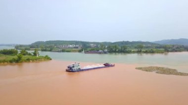 A large sand mining ship sailed past the confluence of two rivers, the intersection of three rivers