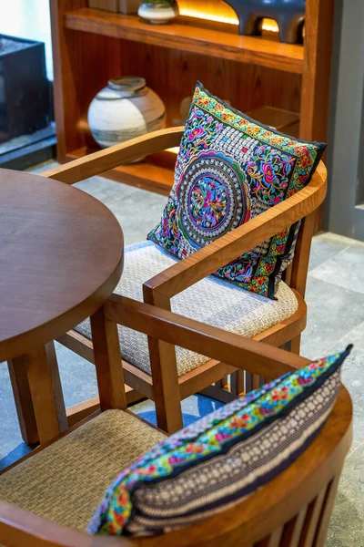Set of throw pillows and table and chair furniture in ethnic style