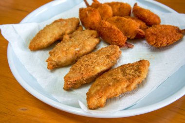 Bir tabak çıtır ve lezzetli kızarmış kelebek karidesi ve kızarmış morina balığı.