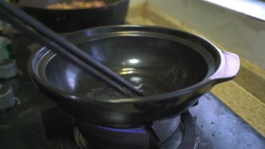 Kanton mutfağında bir şef Çin usulü tavuk güveci yapıyor.