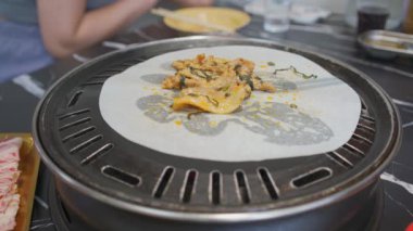 Bir insan kömür kağıdında barbekü yiyor.