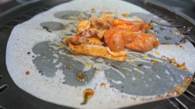 Bir insan kömür kağıdında barbekü yiyor.