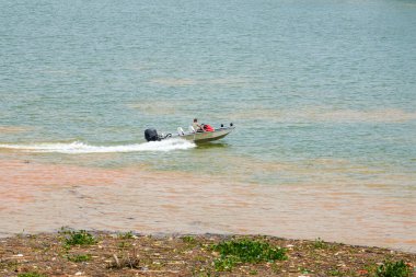 Bir denizci iki nehrin birleştiği yerde sürat teknesi kullanıyor.