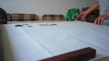 Eski bir kaligraf yazı karakterleri yazıp, yazı işleri yaratıyor. Çevirisi: Mükemmel bir ortam, çay içmek neşe katabilir.
