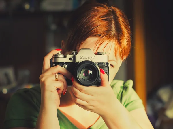 Close -up of the young woman having control over the antiquarian camera. Stock Image