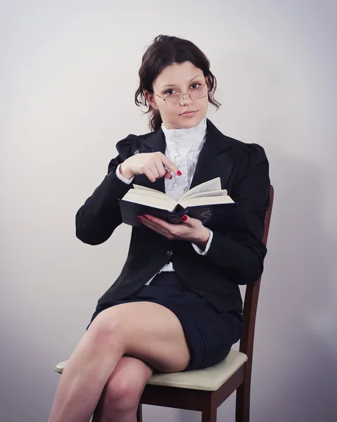 Žena učitel sedí a čtení knihy, samostatný Stock Obrázky