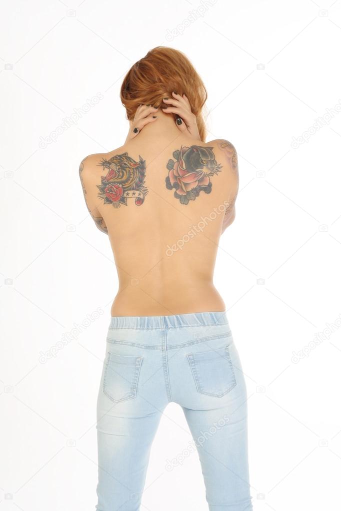 Beautiful woman with tattoos on back and blue jeans