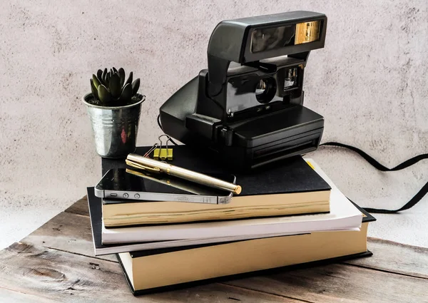 Ofis masasında bir sürü kitap ve defter var.