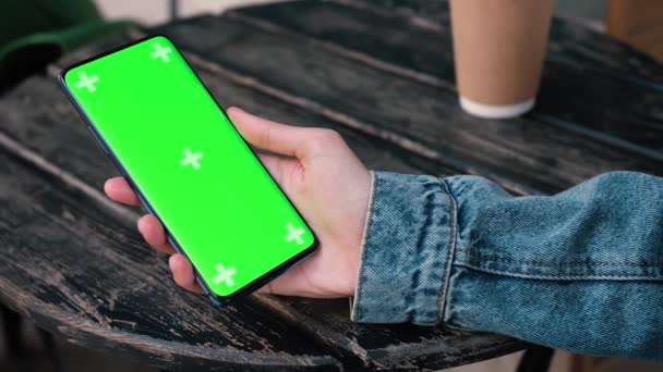 Lviv, Ukraine - May 6, 2022: Close up of a womans hand holding a mobile telephone with a vertical green screen outside chroma key smartphone technology cell phone street touch message display hand — Stock video