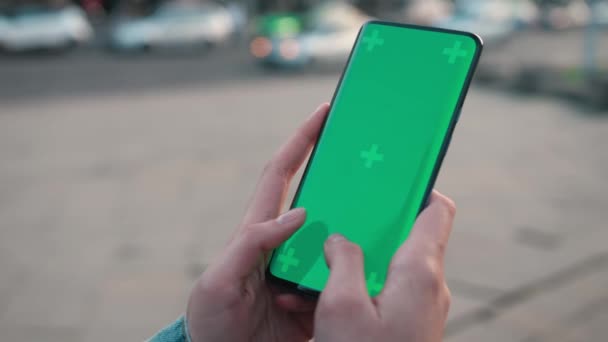 Lwów, Ukraina - 6 maja 2022 r.: Ręce do smsowania dotyku z telefonem komórkowym z pionowym zielonym ekranem na zewnątrz technologii chroma key smartfon telefon komórkowy street touch wyświetlanie wiadomości ręka — Wideo stockowe
