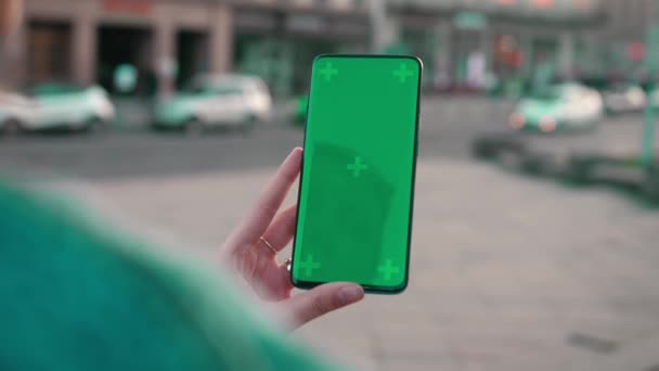 Lviv, Ukraine - May 6, 2022: Close up of a womans hand holding a mobile telephone with a vertical green screen outside chroma key smartphone technology cell phone street touch message display hand — Vídeo de Stock
