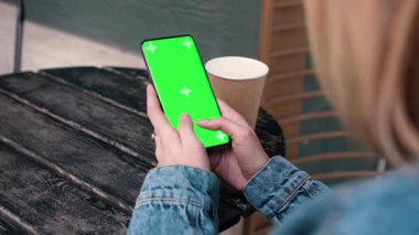 Lviv, Ukrayna - 6 Mayıs 2022: Krom anahtar akıllı telefon teknolojisi cep telefonu teknolojisinin dışında dikey yeşil ekranlı cep telefonuyla cep telefonuna dokunan eller mesajlaşma ekranı