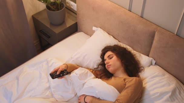 Sleepless caucasian woman watching TV late at night, she is suffering from insomnia — Wideo stockowe