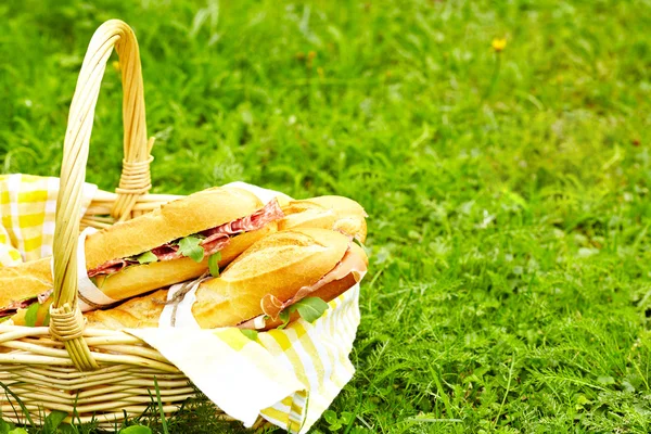 Longa baguete sanduíches na cesta — Fotografia de Stock