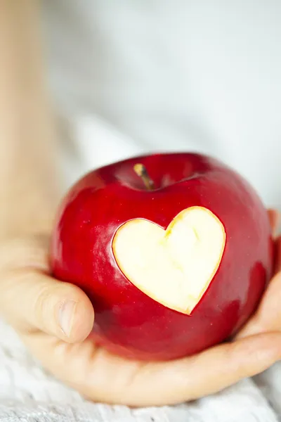 Mano con manzana, que corta el corazón — Foto de Stock