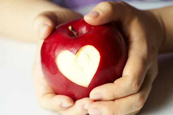 Hand met apple, die hart gesneden — Stockfoto