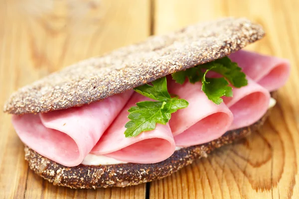 Sandwich con jamón sobre mesa de madera — Foto de Stock