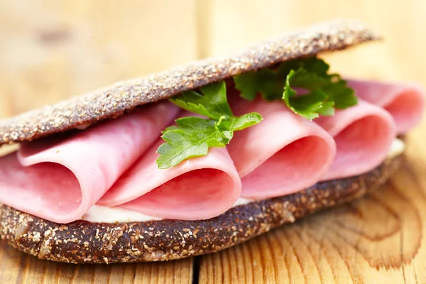 Sandwich met ham op houten tafel — Stockfoto