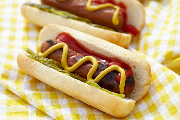 Perros calientes a la parrilla con mostaza, ketchup y sabores —  Fotos de Stock