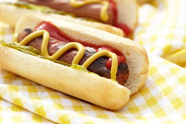 Grillowane hot dogi z musztardą, ketchupem i przyprawami — Zdjęcie stockowe