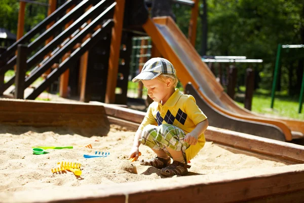 Bambino sul parco giochi nel parco estivo — Foto Stock