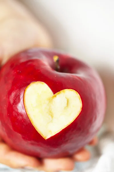 Manzana roja con un corte en forma de corazón — Foto de Stock