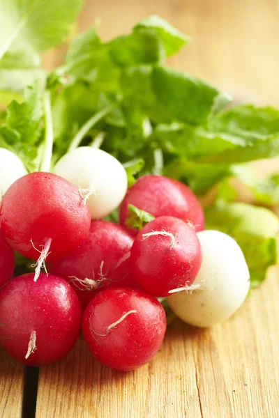 Bunch of fresh radishes on old wooden table — Stock Photo, Image