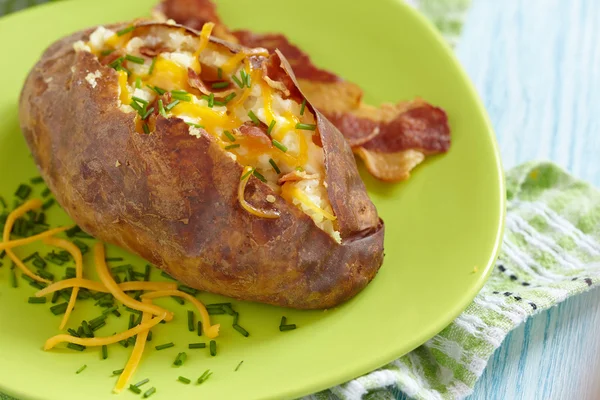 Bakad potatis med bacon, ost och gräslök — Stockfoto