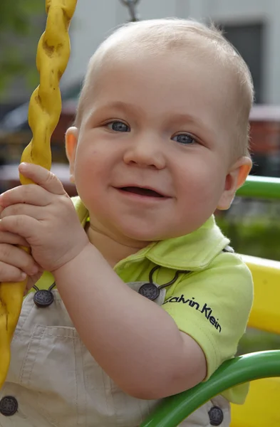 Adorable little boy having fun on a swing outdoor — Stock Photo, Image