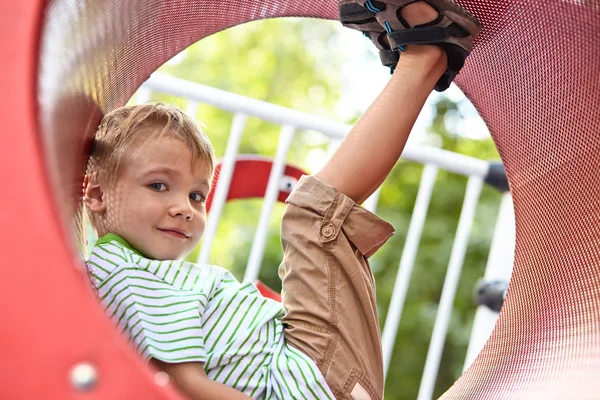 Kid spelar i tunneln på lekplats — Stockfoto