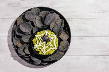 Ürkütücü Cadılar Bayramı siyah patates cipsi ve guacamole sosu