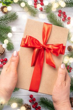 Ahşap zemin üzerinde kırmızı kurdele olan hediye kutusu