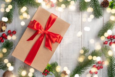 Ahşap zemin üzerinde kırmızı kurdele olan hediye kutusu