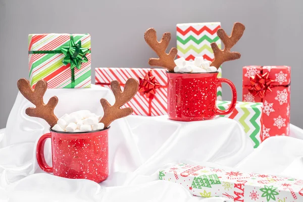Red mug with hot chocolate and gingerbread reindeers horns — Stock Photo, Image