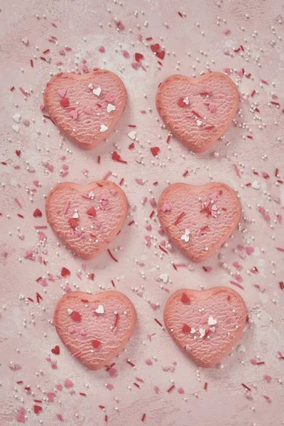 Biscuits décorés en forme de coeur sur fond rose — Photo