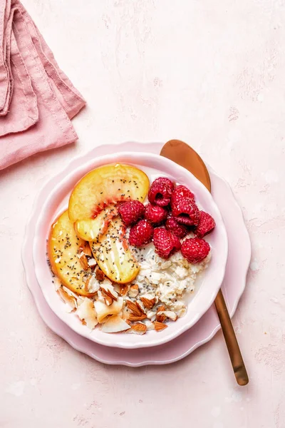 Gachas de avena con frambuesas, melocotones y nueces para el desayuno. — Foto de Stock