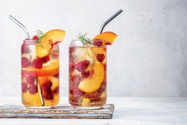 Peach lemonade with soda water and raspberries on grey table. Fresh summer cocktail — Stock Photo, Image