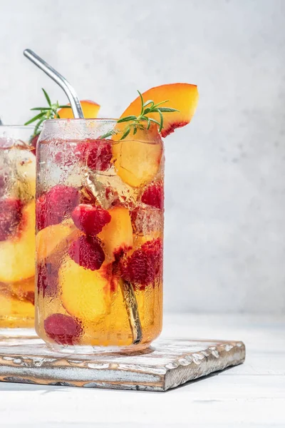 Pfirsich-Limonade mit Sodawasser und Himbeeren auf grauem Tisch. Frischer Sommercocktail — Stockfoto