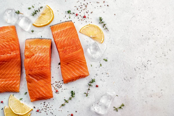 Salmão. Filé de peixe de salmão cru fresco com ingredientes de cozinha, ervas e limão Fotos De Bancos De Imagens